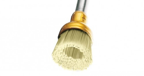 تصویر نمای نزدیک از برس سیلیکونی OptiShine در حال کار روی سطح کامپوزیت برای ایجاد درخشندگی بالا.